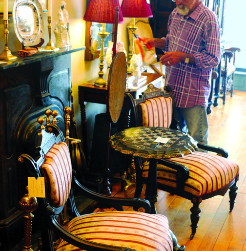 Joe Guarrera arranges new merchandise at the downtown location of the Antiquarius shops. At this time, the downtown shop is open Tuesday through Saturday from 10 a.m. - 5 p.m. daily, while the State Street location is open 10 a.m. - 5 p.m. Friday and Saturday only or by appointment.