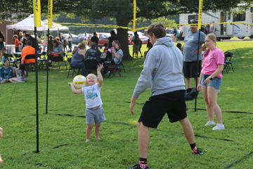 Families enjoy various games on the lawn during the free event as well as a bounce house.