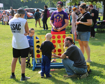 Families enjoy various games on the lawn during the free event as well as a bounce house.