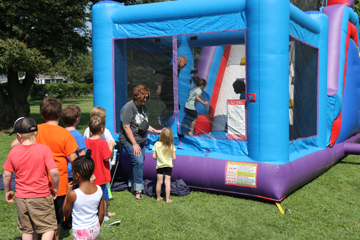 Families enjoy various games on the lawn during the free event as well as a bounce house.
