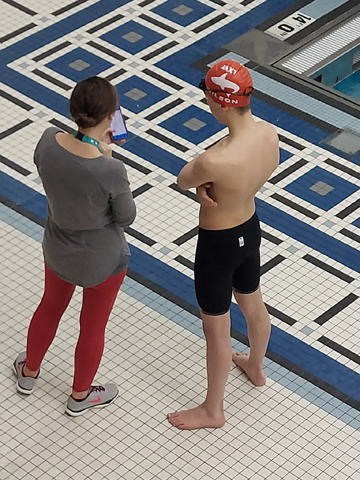 Coach Danielle Schnake talks with Colin Wilson when he was on deck at the 2022 Illinois State YMCA Swimming Championships.