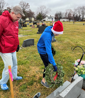 Chad Boehlke, left, and son Ben, 17, both of Jacksonville, place wreaths at Jacksonville East Cemetery as part of Wreaths Across America.