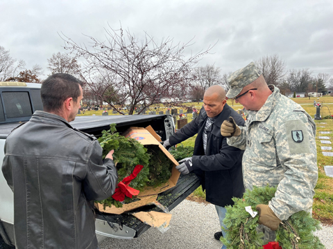 Harvey Sorrell, a member of the Jacksonville cemeteries department, helps Eddie Baldwin Jr., center, and U.S. Army Captain Matt Kephart unload wreaths at Jacksonville East Cemetery. Volunteers then placed the wreaths at gravestones of local military veterans.