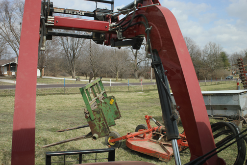 A hay spear is lifted by tractor so that it can be laid out for display at the auction.
